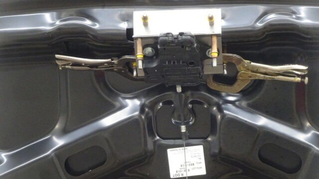 Car trunk latch repair in progress.