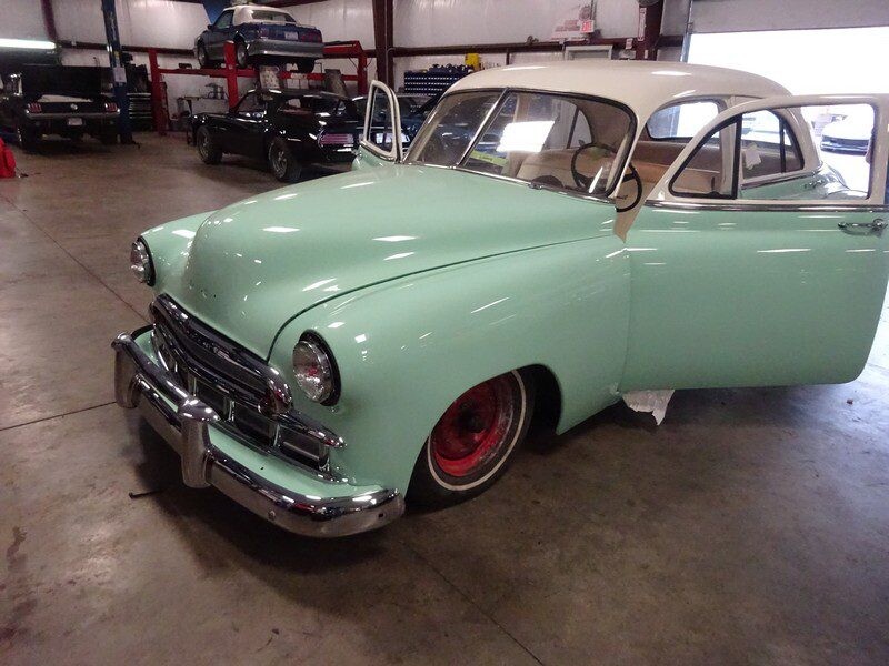 Mint green classic car in garage.