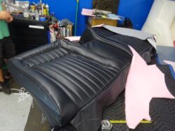 Black leather car seat upholstery in progress.