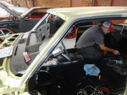 Mechanic working on classic car interior.