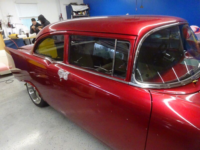 Red classic car in a garage.