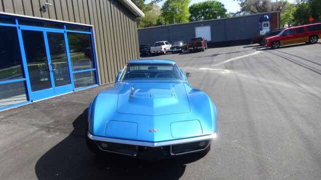 Blue classic Corvette in parking lot.