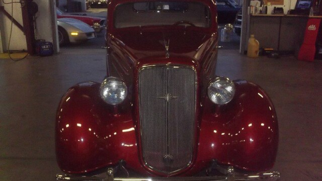 Restored maroon classic car in garage.