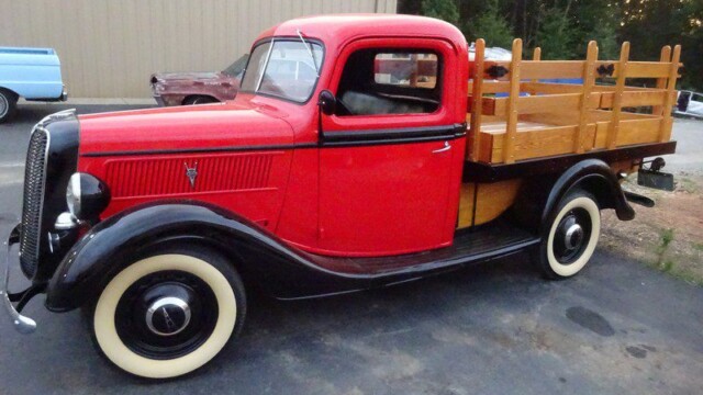 Red vintage Ford pickup truck with wood bed.