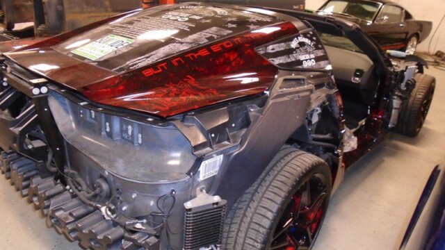 Damaged red, black Corvette under repair.