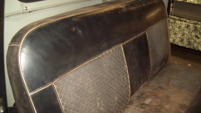Vintage truck's worn leather seat.