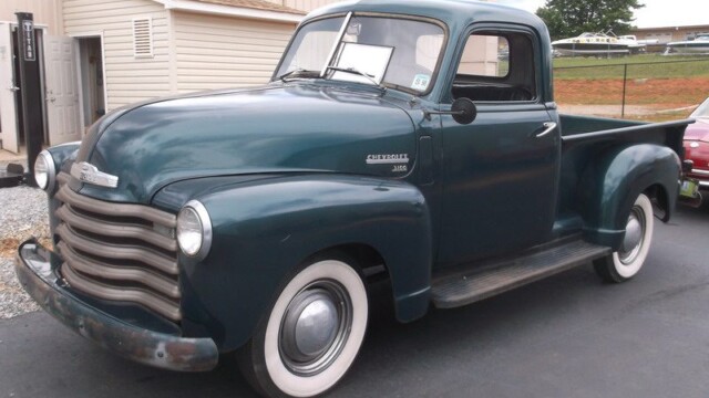 Dark green 1950s Chevrolet pickup truck.