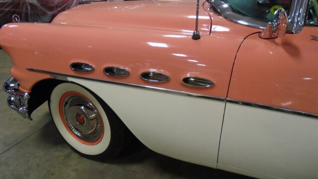 Pink and white vintage Buick car.