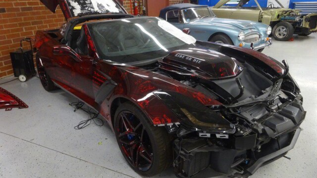 Damaged red Corvette under repair.