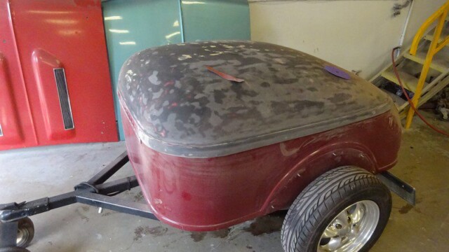 Red vintage trailer awaiting restoration.