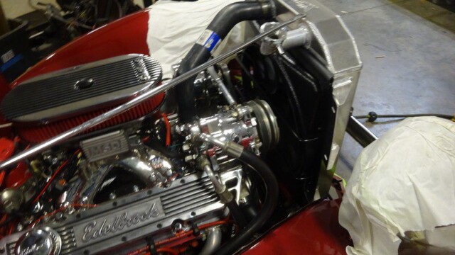 Red car engine with Edelbrock valve covers.
