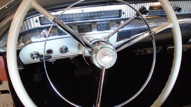 Classic car's cream steering wheel and dash.
