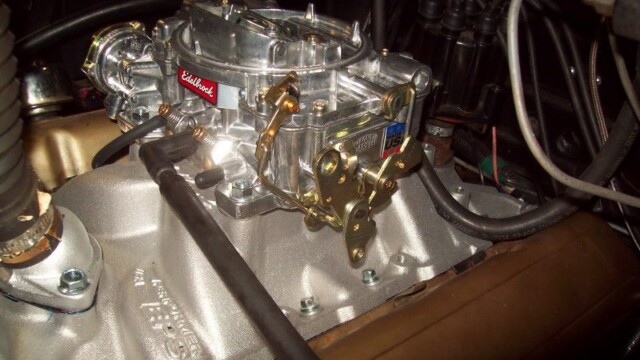 Edelbrock carburetor on engine intake manifold.