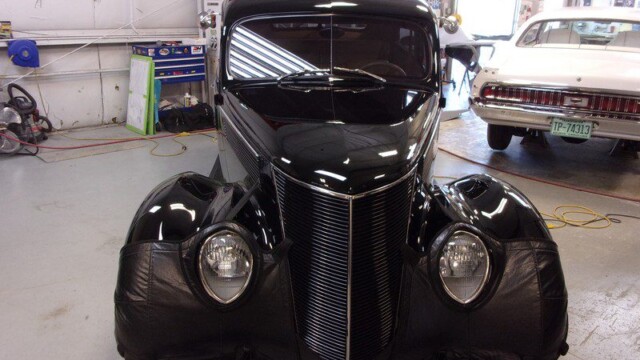 Black classic car in auto shop.