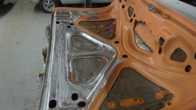 Orange car trunk undergoing repairs.
