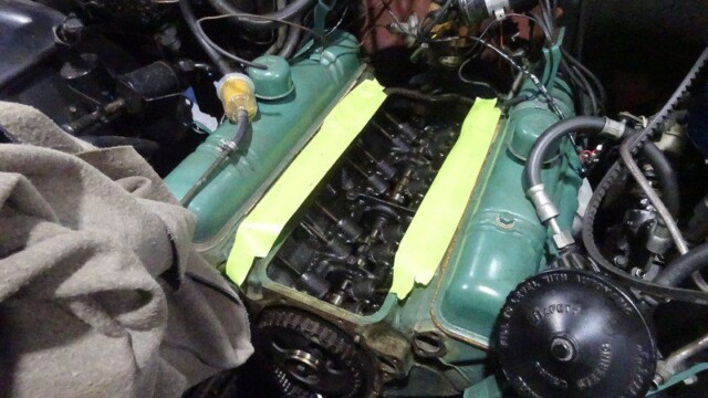 Green car engine with yellow tape.