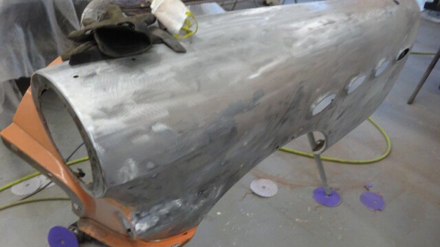 Sanded car panel on stand with gloves