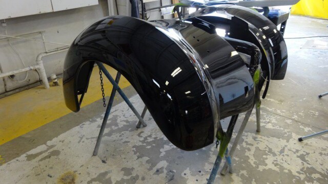 Black car parts drying on stands.