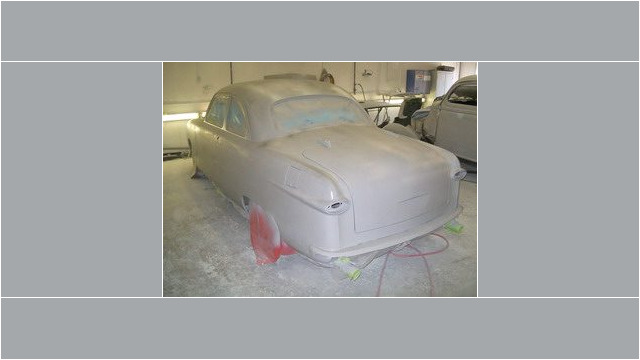 Here's an alt tag for the image: `1950 Ford Custom car body in primer.`