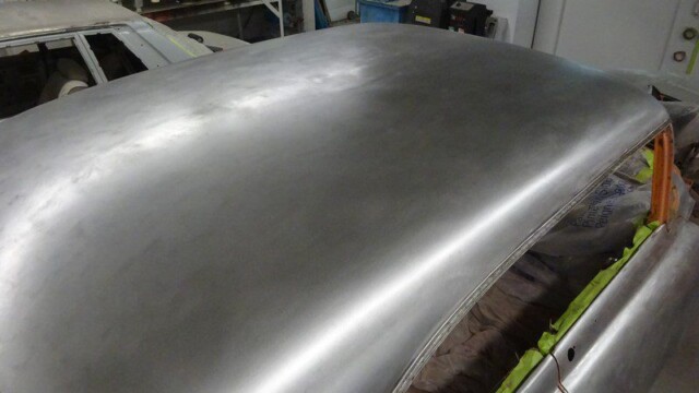 Here's an alt tag for the image: Smooth metal car roof, bodywork in progress.