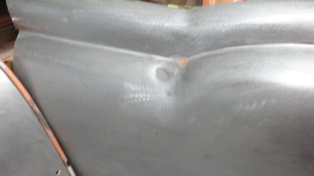 Car body panel, primered metal.