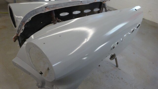 Primed car body panels in progress.