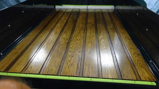 Truck bed with stained wood planks.