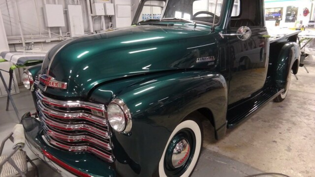 Restored green Chevrolet 1950s pickup truck.