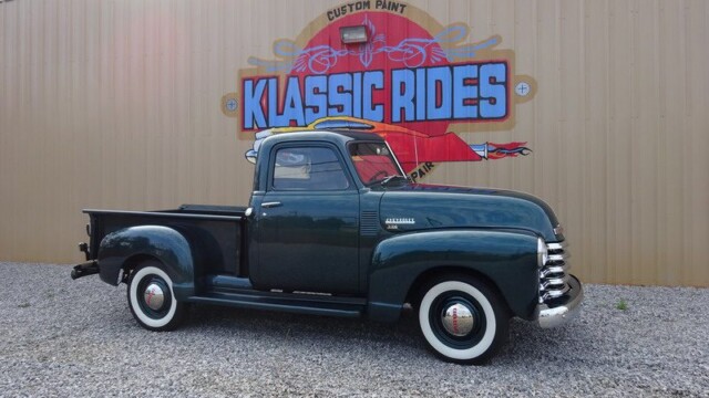 Dark green vintage Chevrolet pickup truck.