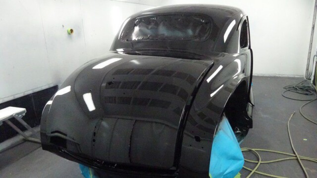 Black classic car in paint booth.