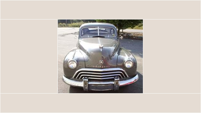 Here's an alt tag for the image: `Vintage Oldsmobile, gray, front view`