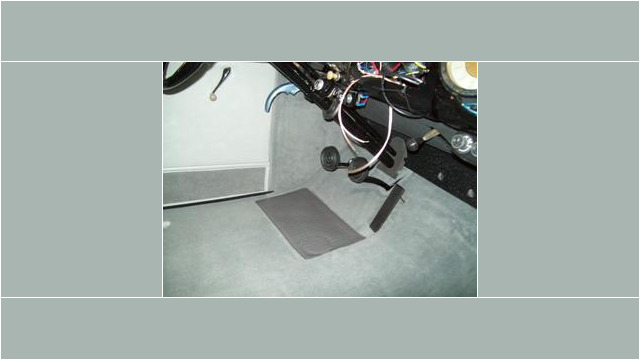 Here's an alt tag for the image: `Gray carpet installed in vintage car interior.`