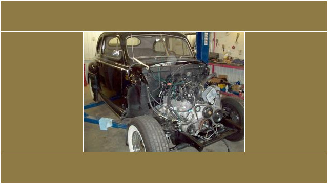 Here's an alt tag for the image: Black classic car engine restoration.