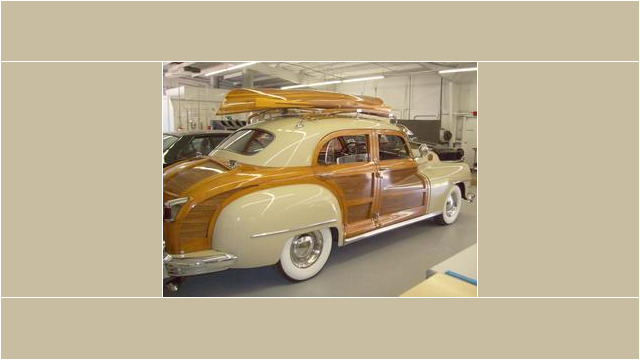 Here's an alt tag for the image: Vintage woody station wagon with canoe.