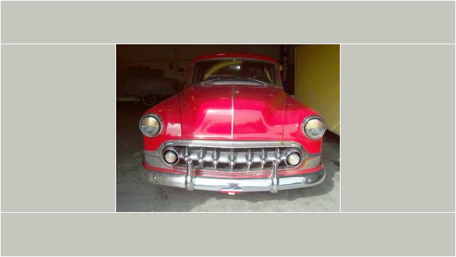 Here's an alt tag for the image: Red vintage Chevrolet car front view.