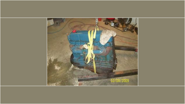 Here's an alt tag for the image: Blue engine hoisted on a stand.