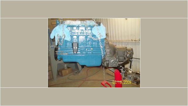 Here's an alt tag for the image: `Engine and transmission suspended by chains`