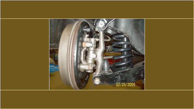 Here's an alt tag for the image: `Classic car suspension and brake drum`