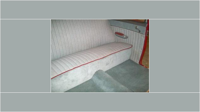 Here's an alt tag for the image: Custom car interior, gray upholstery, red piping.