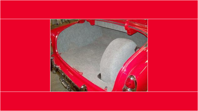 Here's a short alt tag for the image: Red classic car's trunk with spare tire.