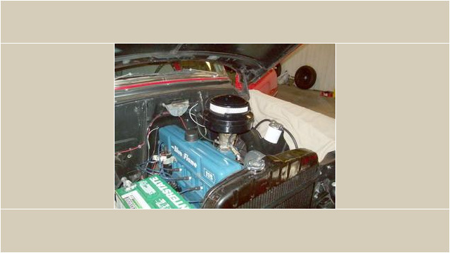 Here's an alt tag for the image: Blue Chevy 216 engine bay.