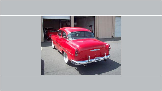 Here's a short alt tag for the image: `Red 1953 Chevrolet classic car`