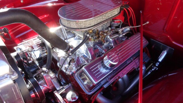 Custom polished engine in red car.