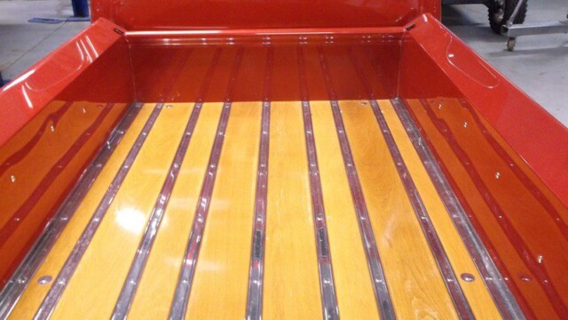 Red truck bed with wooden planks.