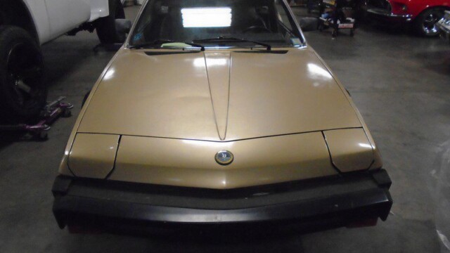 Beige Fiat X1/9 sports car front view.