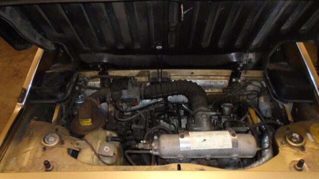 Here's an alt tag for the image: Gold classic car engine bay.