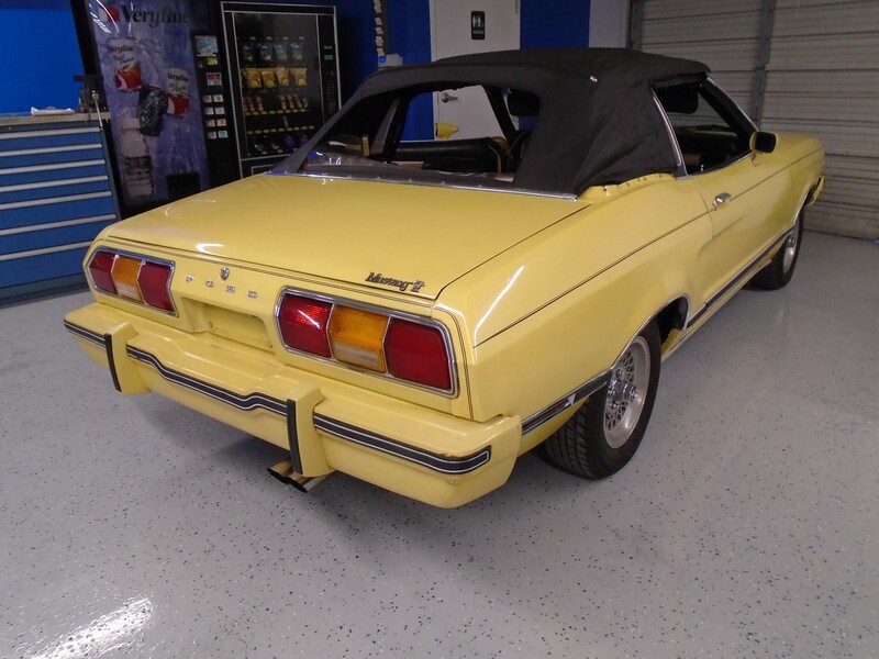 Yellow Ford Mustang II convertible.