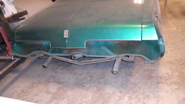 Green classic car rear end damage.
