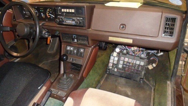 Brown car interior, dashboard, and exposed wiring.