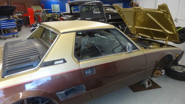 Fiat X1/9 being repaired in a garage.
